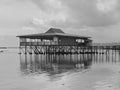 Traditional stilt house with a tranquil scene on a shallow beach Royalty Free Stock Photo
