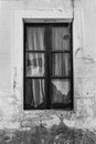 Grayscale vertical closeup of the broken glass window of an abandoned house in Evora, Portugal Royalty Free Stock Photo