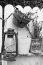 Grayscale vertical shot of flower pots and a lamp on a wooden fence