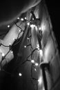 Grayscale vertical shot of lights hanging on a wall