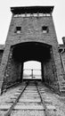 Grayscale vertical shot of main railway entrance to Auschwitz camp in Krakow city, Poland