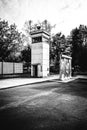 Grayscale vertical shot of observation tower against trees in an empty street