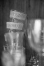 Grayscale vertical shot of a pile of small Polish vodka glasses in a cupboard