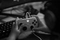 Grayscale view of an Xbox gaming controller in the hands of a player