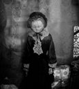 Grayscale of a vintage doll in front of a wall with an ornamental pattern Royalty Free Stock Photo