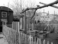 Grayscale of a wooden fence and old railway wagon at the harbor garden in Offenbach, Germany