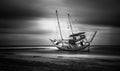 Grayscale of a yacht moored at a beach on a gloomy day shot in long exposure