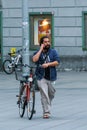 A young bearded man with a mobile phone and a bicycle, Graz, Aus