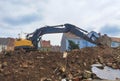 Yellow industrial excavator working on demolition/construction site