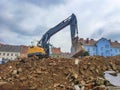 Yellow industrial excavator working on demolition/construction site