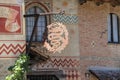 Part of the facade of ancient castle and vintage sign. Grazzano