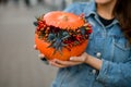 great autumn arrangement of flowers berries and pepper in pumpkin on hands of woman.