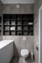 Great bathroom in modern style with gray tiled walls and luminous lamp