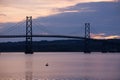 Great blue heron perched on a rock in the St. Lawrence River and the Island of Orleans Bridge seen in silhouette at dawn Royalty Free Stock Photo