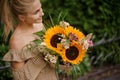 great bright bouquet of sunflowers in hands of young woman Royalty Free Stock Photo