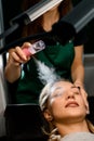 great close-up view of female client and beautician moisturizes her face with steam from portable humidifier