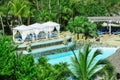 Great comfortable white gazebos near the pool in tropical palm trees garden