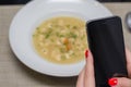 Great concept of social media, woman hand taking photo of food soup