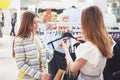 Great day for shopping. Two beautiful women with shopping bags looking at each other with smile while walking at the