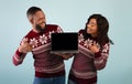 Great discounts and sales for New Year. Excited african american couple pointing at laptop with blank screen Royalty Free Stock Photo