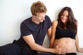 Great expectations. a happy young man touching his pregnant wifes belly. Royalty Free Stock Photo