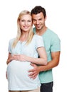 Great expectations. A smiling husband holding his pregnant wifes stomach from behind. Royalty Free Stock Photo