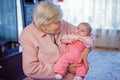 Great grandmother holding newborn baby grandchild on arm Royalty Free Stock Photo