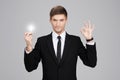 Great idea! Hansome young businessman holding a light bulb