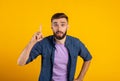 Great idea. Young guy pointing finger up, gesturing eureka, having inspirational AHA moment on orange background Royalty Free Stock Photo