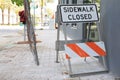 Sidewalk Closed Sign with Fence Texture Background