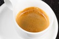 Great italian coffee in a white cup on black wood table