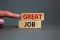 Great job. Wooden blocks with words `great job` on beautiful grey background. Male hand. Business and great job concept, copy