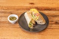 Great Mexican burrito filled with carnitas with rice and pico de gallo, chili sauce