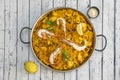 Great mixed seafood and chicken Valencian paella presented in a paella pan with squid, prawns, mussels