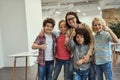 Great moments. Friendly school team of four positive little pupils and their nice female teacher posing together Royalty Free Stock Photo