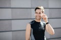 Great mood and sport. Smiling guy in sportswear with fitness tracker puts on headphones Royalty Free Stock Photo