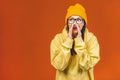 Great news! Cheerful happy pretty girl telling secret on orange background