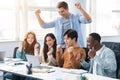 Group of international people using laptop and shaking clenched fists Royalty Free Stock Photo