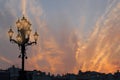 Great old lamppost, city roofs and mystical fiery sunset