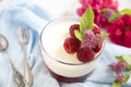 Great panacotta dessert with raspberries, on a blue background and vintage spoon and fork.