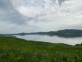 Great panoramic view. A clean mountain lake in the midst of majestic mountains in a haze of fog. On the Sunset. Copy Royalty Free Stock Photo