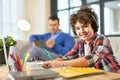 Great place to learn. Cheerful hispanic school boy wearing headphones, smiling at camera while preparing homework Royalty Free Stock Photo