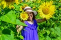 Great plants. yellow flower of sunflower. happy childhood. beautiful girl wear straw summer hat in field. pretty kid Royalty Free Stock Photo