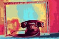 An old telephone and a frame with a colored background