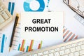 Great Promotion is written in a document on the office desk, diagram and keyboard