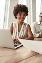 Great results Young and beautiful afro american woman working on laptop and looking away with smile while sitting at the Royalty Free Stock Photo