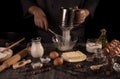 Great set of ingredients for baking, hand of pastry chef beat with whisk eggs, isolated on black