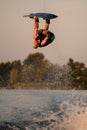 great shot of an athletic male wakeboarder upside down while jumping and flipping