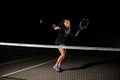 great shot of tennis ball in air and female tennis player with racket ready to hit it