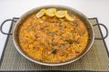 Great Spanish vegetable paella presented in its paella pan with lemon